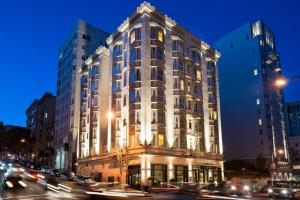 a large building on a busy city street at night at Staypineapple, An Elegant Hotel, Union Square in San Francisco