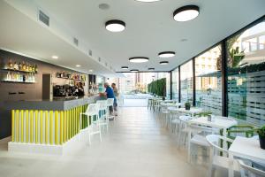 a restaurant with white tables and chairs and a bar at Primavera Loix in Benidorm