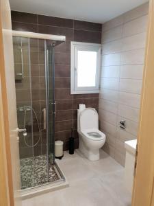 ein Bad mit einem WC und einer Glasdusche in der Unterkunft Egkomi Luxury Suites in Nikosia