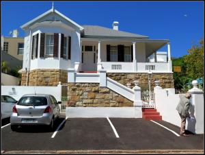 een auto geparkeerd op een parkeerplaats voor een huis bij Stonehurst Guest House in Kaapstad