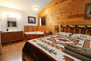 a bedroom with a bed and a tub and a sink at Dancing Bear in Sevierville