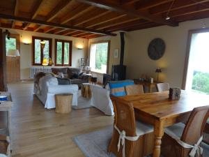 a living room with a wooden table and chairs at Maison d'hôtes l'Arnica in La Bréole