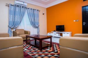 a living room with a table and chairs and a tv at Résidence Soleil d'Afrique in Cotonou