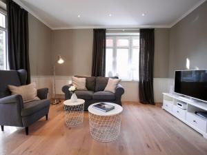 ein Wohnzimmer mit einem Sofa und einem TV in der Unterkunft Kleine Charlotte - Traumwohnung mit Terrasse für 4 Personen in Wangerooge