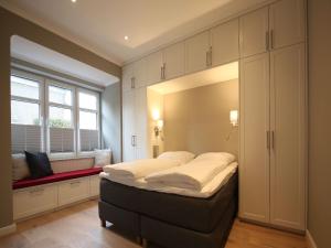 ein Schlafzimmer mit einem großen Bett und einem Fenster in der Unterkunft Kleine Charlotte - Traumwohnung mit Terrasse für 4 Personen in Wangerooge