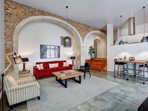 ein Wohnzimmer mit einem roten Sofa und einem Tisch in der Unterkunft Lisbon Canaan Boutique Apartments Gaivotas by Get Your Stay in Lissabon