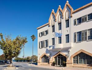 a large white building with a flag on it at Albergo Gelsomino in Kos Town