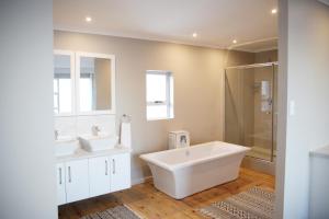 a white bathroom with two sinks and a shower at Eden Guesthouse B&B in Dana Bay +47 photos