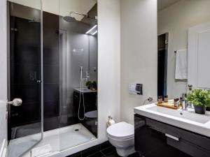 a bathroom with a shower and a toilet and a sink at Lisbon Canaan Boutique Apartments Gaivotas by Get Your Stay in Lisbon