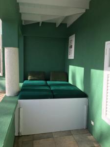 a green room with a bed in the corner at The Atlantis Historic Inn in Saint Joseph