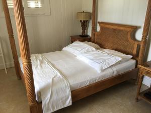 a bed with a wooden frame and white sheets and pillows at The Atlantis Historic Inn in Saint Joseph