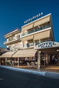 a hotel with tables and chairs in front of a building at Hotel Plaza in Nea Stira