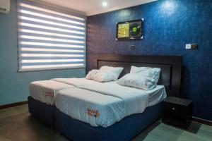 
a bed in a room with a blue wall at Kalakuta Museum in Ikeja
