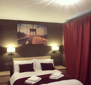 a bedroom with a bed with two towels on it at Bede Apartments in Coventry