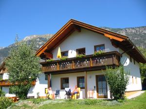 eine Gruppe von Menschen, die vor einem Haus sitzen in der Unterkunft Ferienhaus Warmuth in Sankt Stefan an der Gail