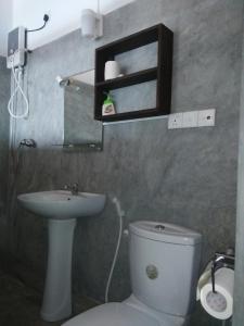 a bathroom with a white toilet and a sink at Asiri Yoga Retreat in Galle