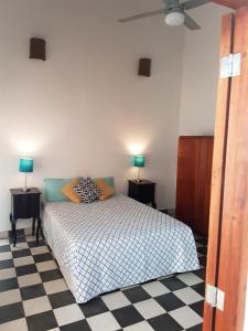 a bedroom with a bed and two lamps on two tables at Lovely new-build colonial house with plunge pool in Granada