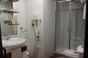 
a bathroom with a toilet, sink, and shower at Hotel Las Casas del Consul in Úbeda
