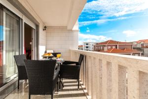uma varanda com uma mesa e cadeiras. em Apartments Jozic em Trogir
