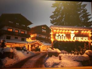 a hotel with lights on it in the snow at Hotel Principe in Cortina dʼAmpezzo