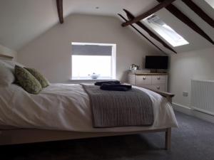 a bedroom with a large bed and a window at The Cricketers Arms in Petworth