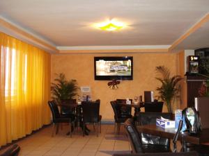 a restaurant with tables and chairs and a tv on the wall at Vila Tom Cris in Câmpina