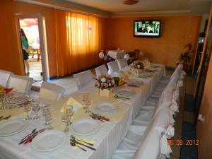 a long table with white linens and white chairs at Vila Tom Cris in Câmpina