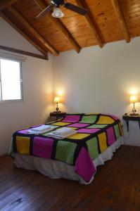 a bedroom with a bed with a colorful blanket at Rancho Pampa in Villa Ciudad Parque