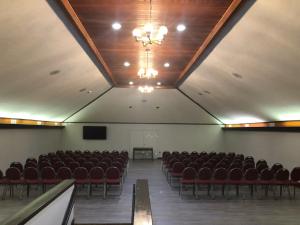 an empty room with chairs and a podium and a screen at Springfield Inn TN in Springfield