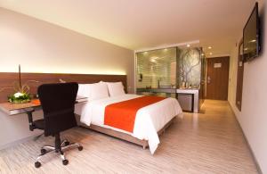 a hotel room with a bed and a desk and a chair at SHG Bogotá 100 Design Hotel in Bogotá