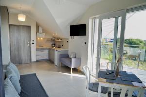 a kitchen and a living room with a table and chairs at Willa Dobryłko in Rewa