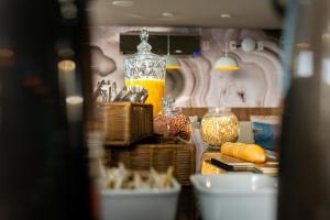 a counter with food and a jar of orange juice at Íbis Styles Itaúna in Itaúna
