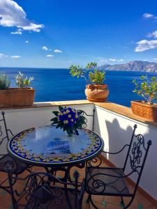 a table on a balcony with a view of the ocean at La dimora degli Dei in Praiano