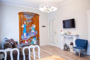 a living room with a couch and a painting on the wall at Cherry House Apartments in Bydgoszcz