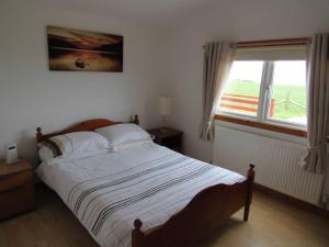 een slaapkamer met een groot bed en een raam bij Golden Oak Chalet in Dunbar