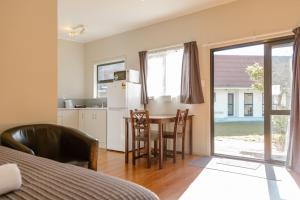 a room with a kitchen and a table with chairs at Sunset Motel in Thames