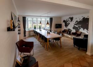 una sala de estar con una mesa y un mapa mundial en la pared en Sdr. Omme Bed & Breakfast en Sønder Omme