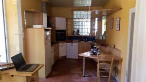 a kitchen with a laptop computer on a table at LE POINT DU JOUR in Saint-Savin