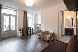 a living room with a couch and a table and a window at Appart République parking privé gratuit in Lille