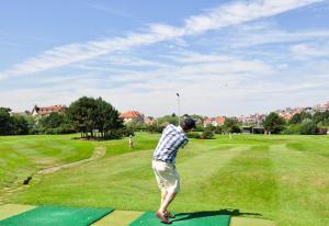 a man is standing on a putting green at Residentie Mariposa in Knokke-Heist