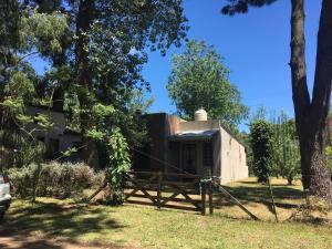 an old house with a fence in front of it at Santa Teresita en el monte in Santa Teresita