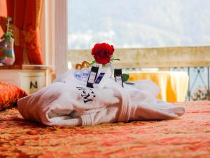 uma mão de plástico com uma flor em cima de uma cama em Hotel Miralago em Cernobbio