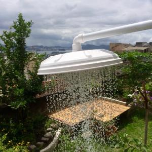 a bird feeder in a garden with a fountain at Casa igba in Rio de Janeiro