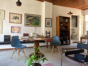 a living room with a wooden table and blue chairs at Casa igba in Rio de Janeiro