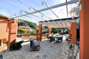 a patio with a pergola and tables and chairs at Pyramid City Apartments in St. Spyridon Corfu