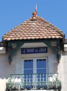una finestra su un edificio con un cartello sopra di LE POINT DU JOUR a Saint-Savin