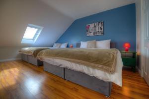 a bedroom with two beds and a blue wall at Spanish Arch in Galway