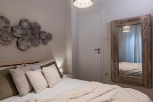 een slaapkamer met een bed met een spiegel aan de muur bij Acropolis, Urban Lifestyle apartment in Athene
