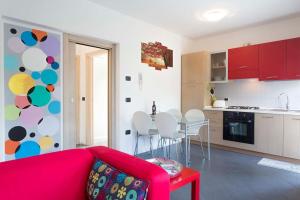 a living room with a red couch and a kitchen at Peace apartment in Arco