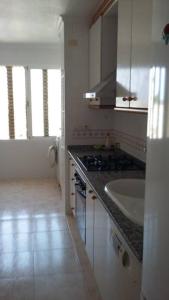 eine weiße Küche mit einer Spüle und einer Theke in der Unterkunft Apartamento Venecia in Águilas